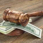 A Wooden Gavel on A Pile of Money