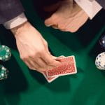 A Man Looking at His Cards on A Poker Table