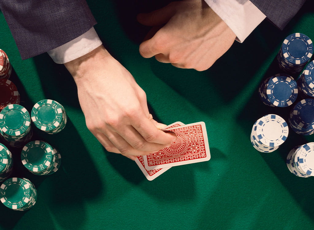 A Man Looking at His Cards on A Poker Table 