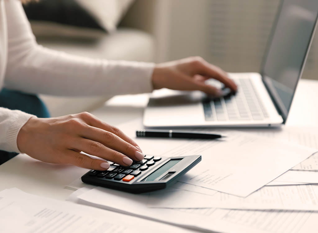 Woman on Laptop with a Calculator